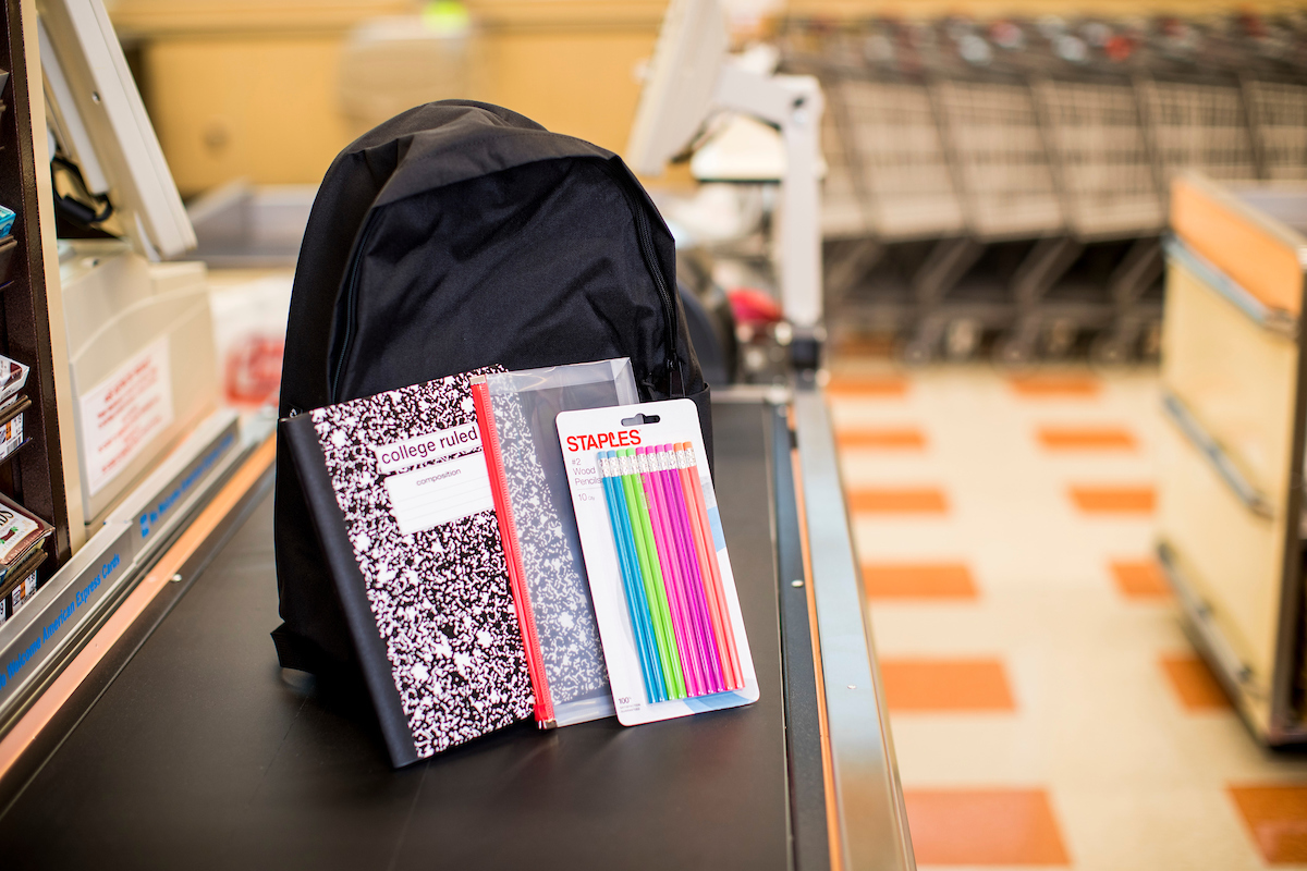 Black backpack with composition notebook, pencil pouch, and pack of pencils